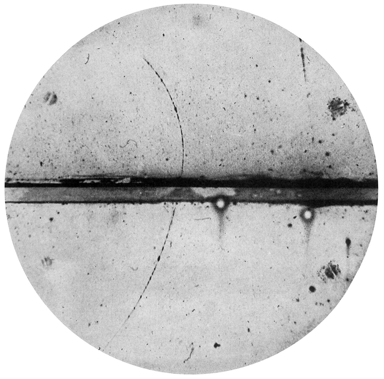 Anderson's cloud-chamber photograph of the positron — a thin curved track crossing a vertical lead plate.