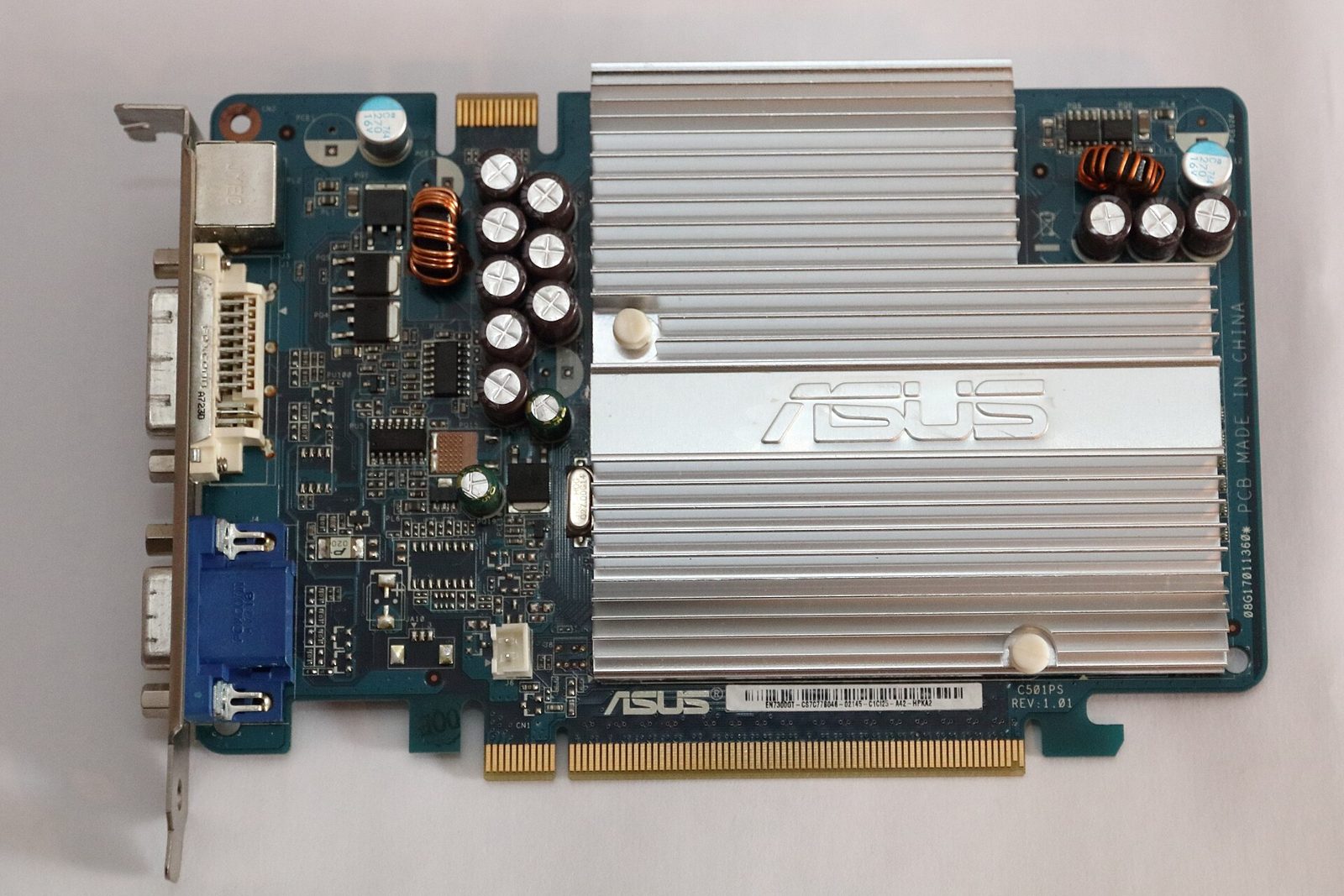A green Nvidia GeForce graphics card circuit board with a silver heat sink, photographed on a plain white background.